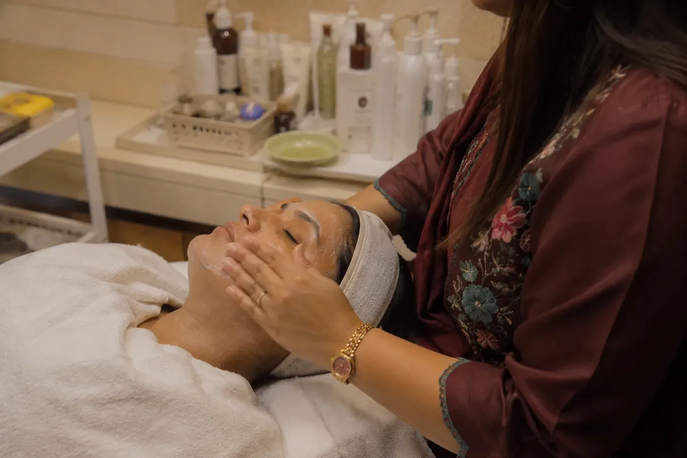 A beautician giving a facial treatment in a salon